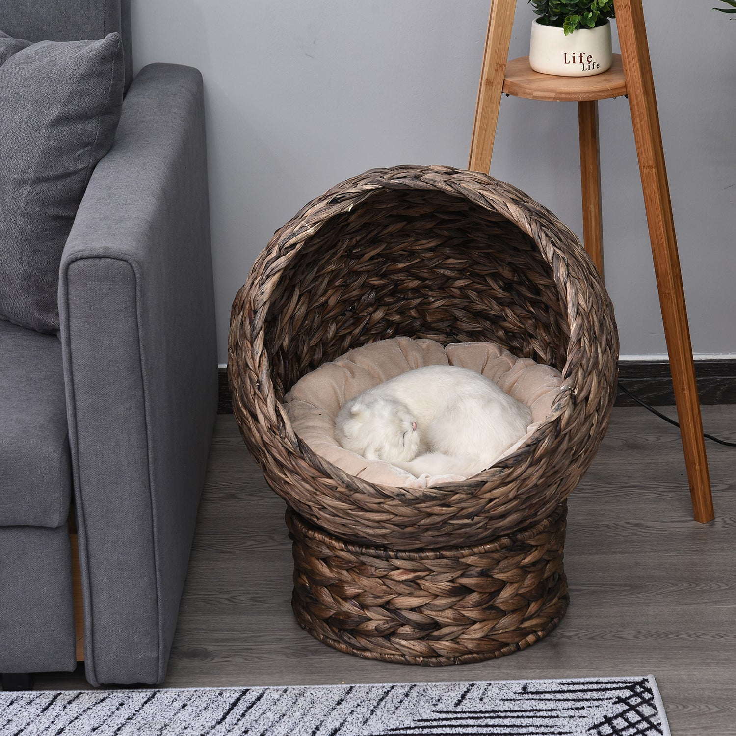 LUXENEST HOME Handwoven Wicker Cat Egg Chair with a soft cushion and a white cat lounging inside.